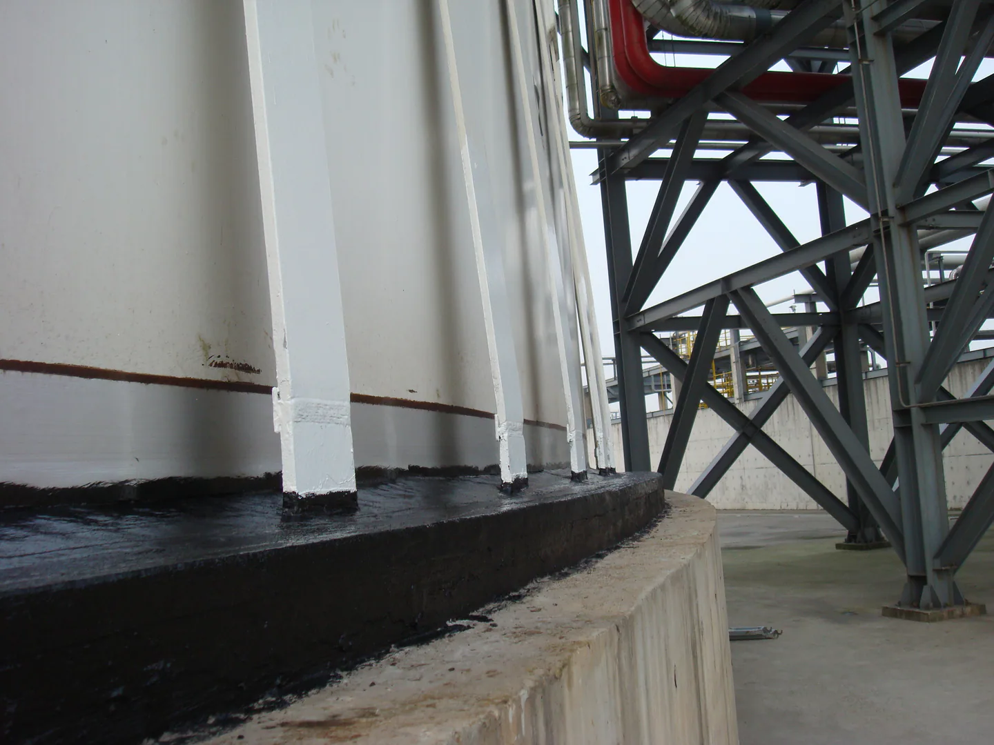 Completed storage tank edge protection around shell supports and the concrete foundation.