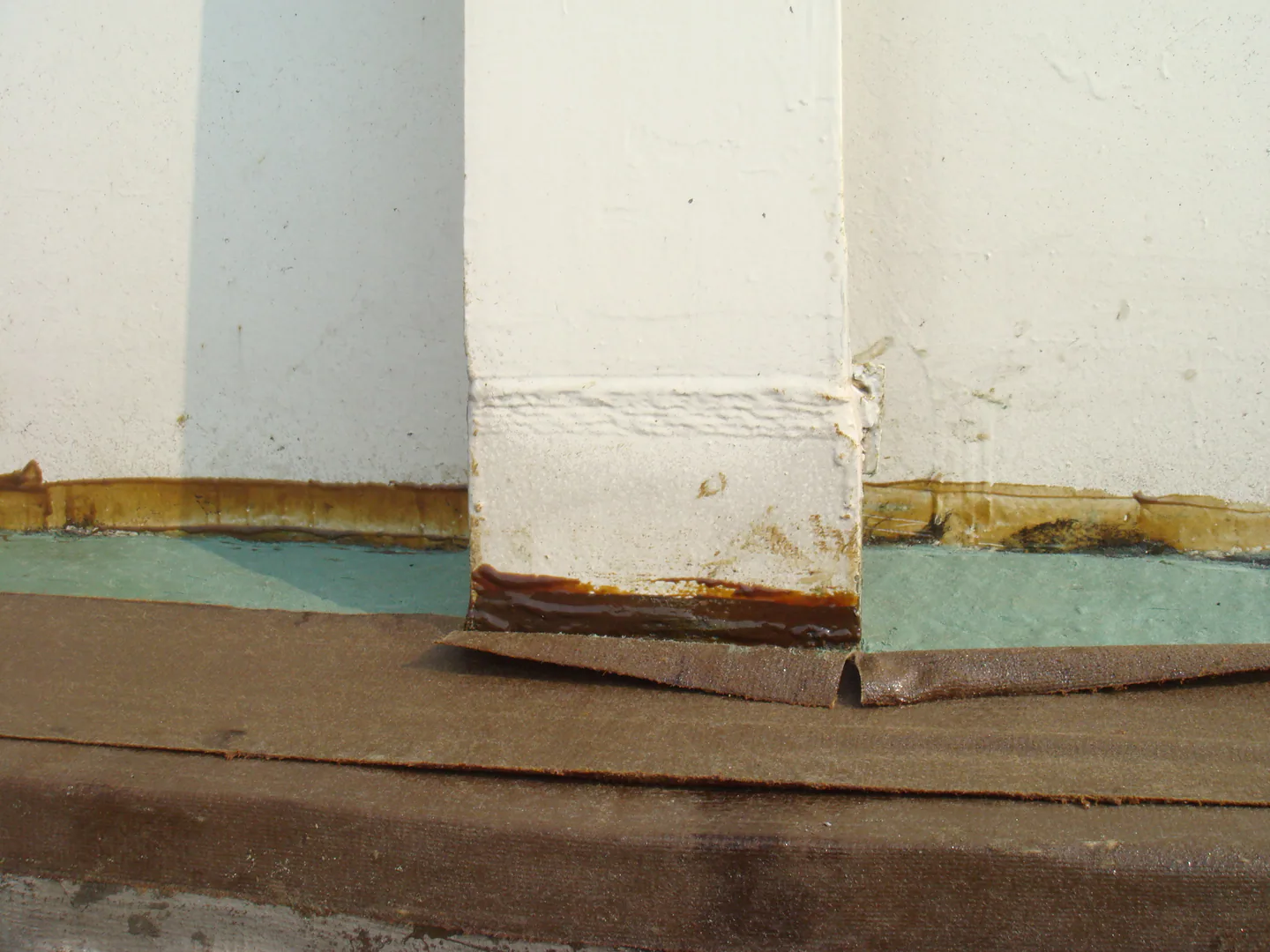 Close view of the protected transition beneath a storage tank shell support.